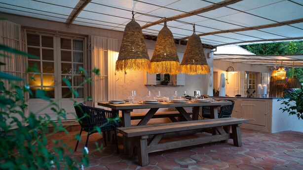 An outdoor patio with a wooden table and benches, surrounded by hexagonal stone tiles. - Villa Les Muscadines Saint Tropez, Tahiti Pampelonne beach, heated pool. (Saint-Tropez)
