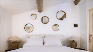A neatly arranged bedroom with a large bed, two bedside tables with lamps, and five wall-mounted mirrors. - Villa Les Muscadines Saint Tropez, Tahiti Pampelonne beach, heated pool. (Saint-Tropez)