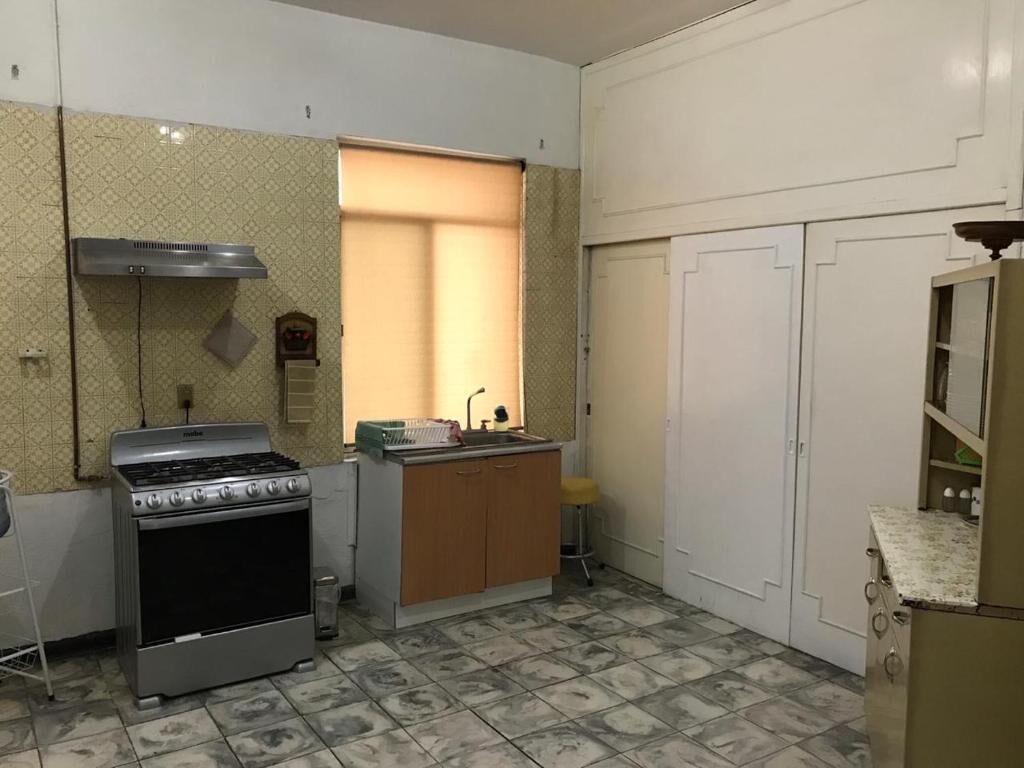 Cocina compacta con estufa a gas, un lavamanos y una pequeña encimera.