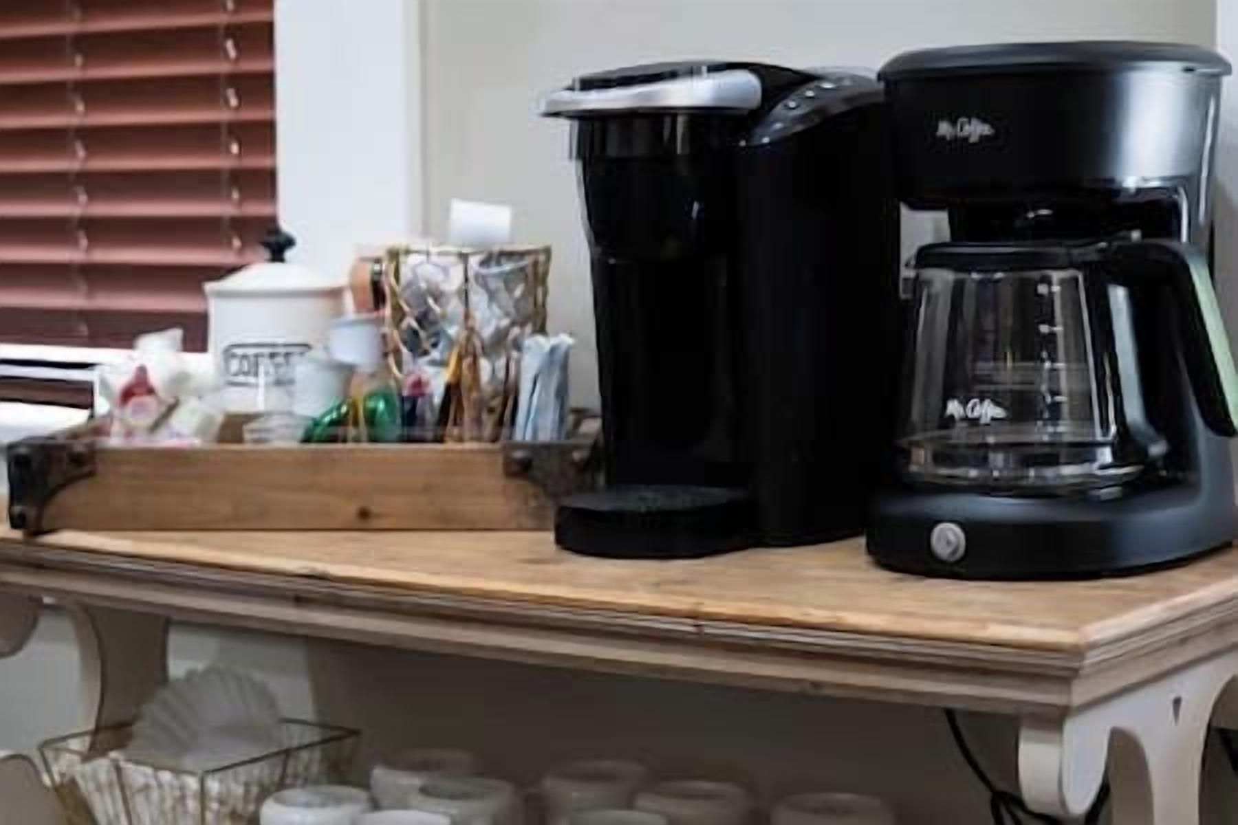 A coffee maker and a toaster on a wooden countertop.