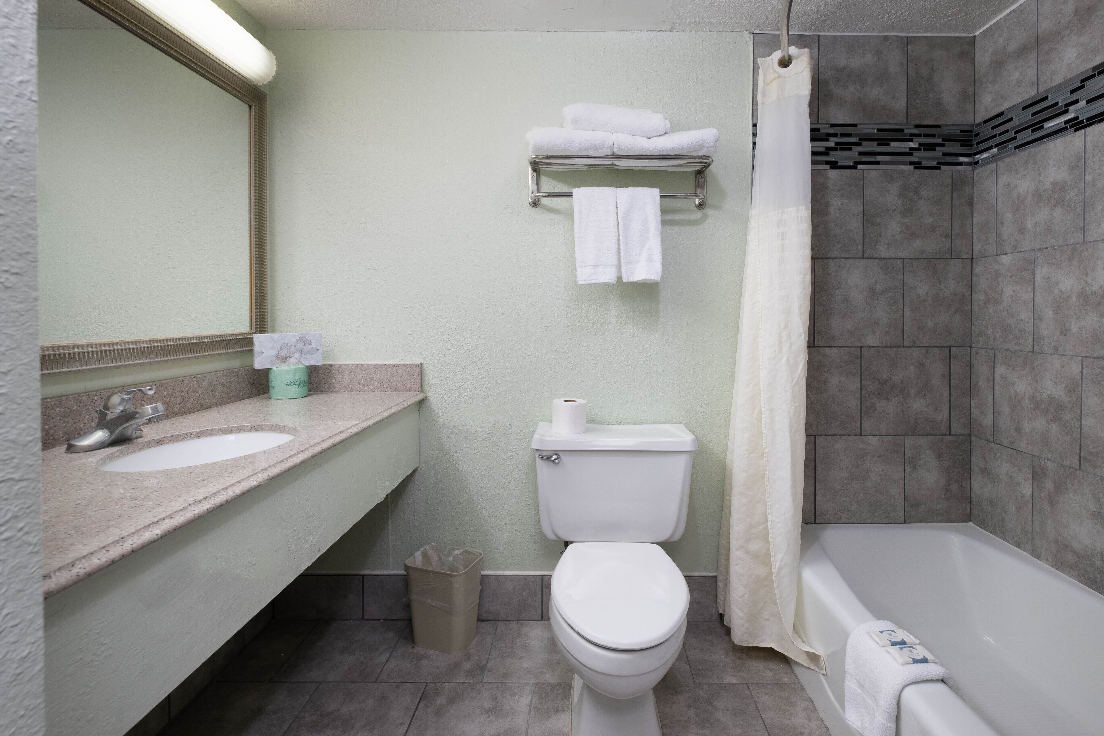 A bathroom with a sink, toilet, and bathtub.