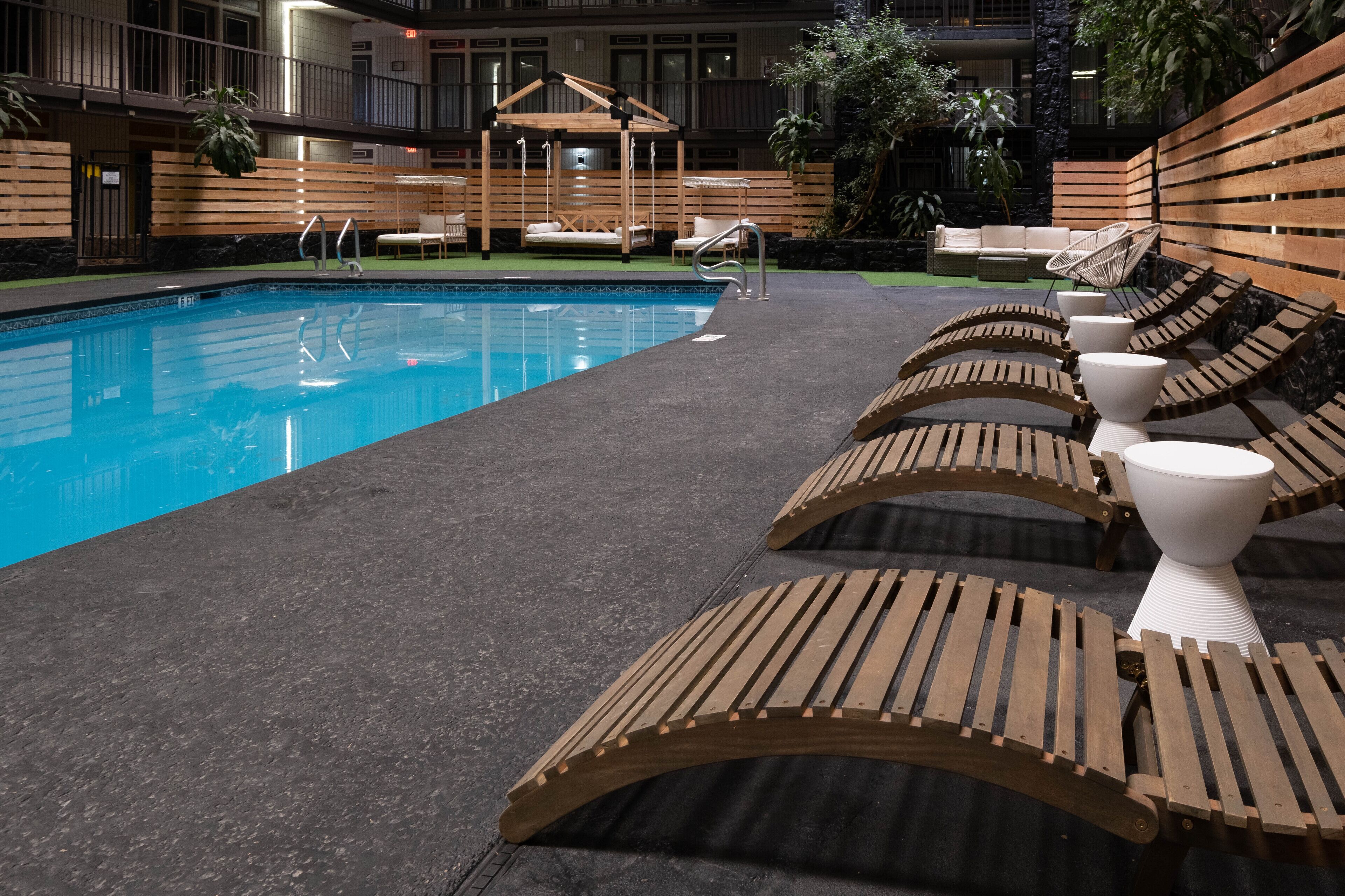 A pool area with wooden loungers and a wooden deck.