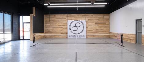 A spacious indoor area with a wooden wall and a sign reading "Cactus Cove Inn & Suites".