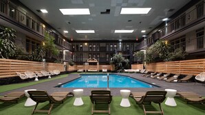 A pool area with multiple lounge chairs and a small gazebo. - The Cactus Cove Inn and Suites (Amarillo)