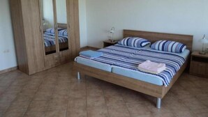 A bedroom with a bed, a wardrobe, and a nightstand. - Apartment 100m from sea, with covered terrace, citrus trees (Sveti Filip i Jakov)