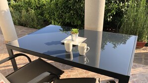 A glass-top table with a white mug and a small potted plant. - Apartment 100m from sea, with covered terrace, citrus trees (Sveti Filip i Jakov)