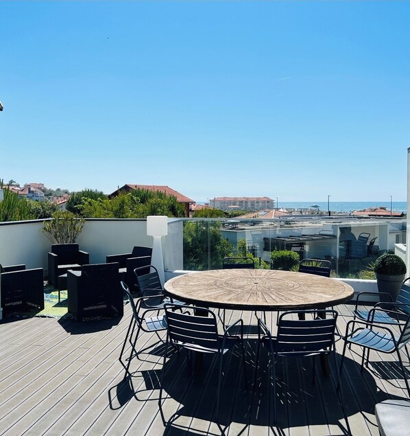 Enjoy panoramic views from this elevated rooftop terrace with a round table and comfortable seating.