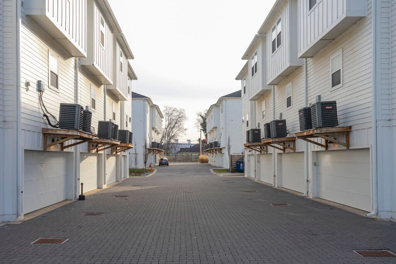 Une rangée de bâtiments blancs, chacun équipé de climatiseurs fixés à l’extérieur.