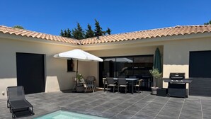 A backyard with a swimming pool, outdoor furniture, a grill, and a covered patio area. - Beautiful villa in the south of France (Argilliers)
