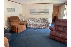 Cozy living area with a sofa, armchairs, and a wall-mounted artwork.