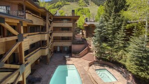Un chalet en bois doté de plusieurs balcons et d’un espace piscine.