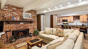 Ein Wohnzimmer mit Kamin aus Backsteinen, einer Couch und einem Couchtisch.