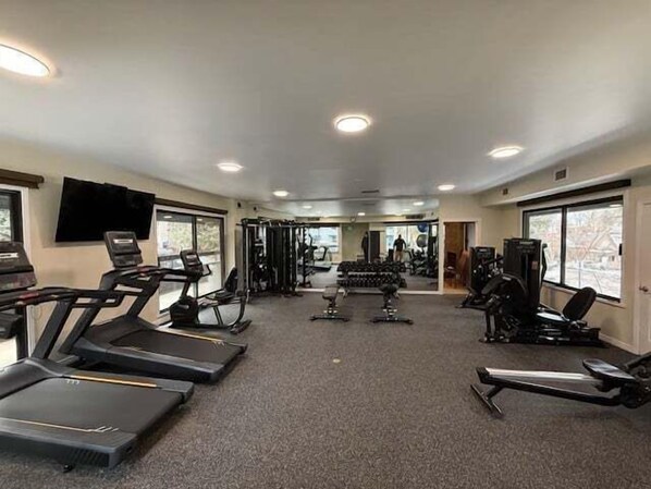 A gym with treadmills, weight machines, and free weights.