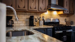 A kitchen with a gas stove, oven, and coffee maker. - Chesapeake Chalet- Cozy,Close to Hard Rock and All (Atlantic City)