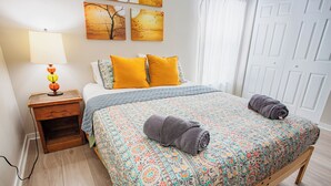 A neatly made bed with a patterned bedspread, two pillows, and a rolled towel. - Chesapeake Chalet- Cozy,Close to Hard Rock and All (Atlantic City)