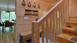 Ein Holzinnenraum mit Treppe, Essbereich und einem an der Wand befestigten Kleiderhaken.