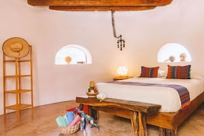 Une chambre confortable avec un lit en bois, deux fenêtres, une échelle en bois et un luminaire suspendu.