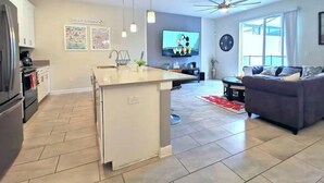 A modern kitchen with a central island, a dining area with a sofa, and a ceiling fan. - *Amazing 4Bdr TH*15mins to Disney*Free Amenities! (Kissimmee)