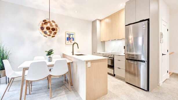 A modern kitchen with a central island, stainless steel appliances, and a pendant light. - Perfect 2bdr in the hart of Montreal (Montréal)