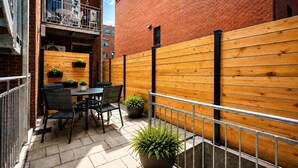 A patio with a table and chairs, potted plants, and a wooden fence. - Perfect 2bdr in the hart of Montreal (Montréal)