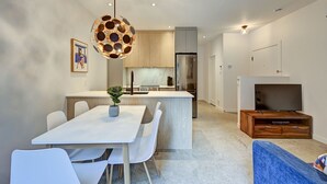 A modern kitchen with a central island, white cabinetry, and a stainless steel refrigerator. - Perfect 2bdr in the hart of Montreal (Montréal)