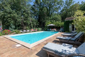 A rectangular swimming pool with a tiled edge, surrounded by lounge chairs and a small covered seating area. - New ! Enchanting Villa 4 bedrooms 4 bathrooms (La Garde-Freinet)