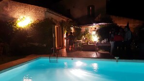 A swimming pool with a ladder, surrounded by a patio area with outdoor seating and string lights. - New ! Enchanting Villa 4 bedrooms 4 bathrooms (La Garde-Freinet)
