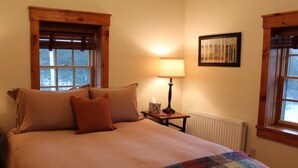 A bedroom with a bed, a lamp, a framed picture, and windows. - Large Log Cabin in the Heart of the ADKS (Keene)