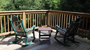 A wooden deck with two rocking chairs and a small table. - Large Log Cabin in the Heart of the ADKS (Keene)