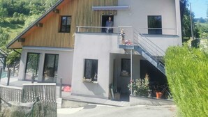 A two-story building with a wooden facade, a balcony, and a small entrance.