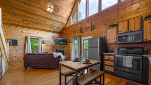 A cozy cabin interior with a wooden interior, a dining area with a bench, a sofa, and a fireplace. - Leconte Lookout - Stunning Views - Hot Tub - Games (Sevierville)