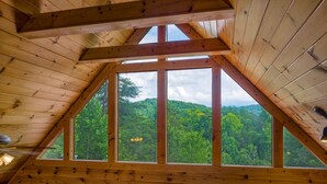 A wooden cabin with a triangular roof and large windows overlooking a forested hillside. - Leconte Lookout - Stunning Views - Hot Tub - Games (Sevierville)