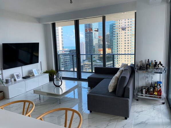 Relax in this stylish living room with a large flat-screen TV, comfortable sofa, and city views.