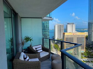 Relax on the balcony with a wicker sofa set and take in the city views of high-rise buildings and the ocean.