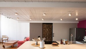 A modern kitchen with a large island, wooden furniture, and a decorative door.