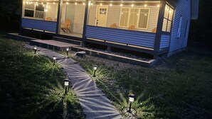 A house with a porch, wooden chairs, and string lights. - Modern Mountain Getaway with Fire Pit (Shandaken)