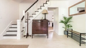 A staircase leading to a second floor, a wooden dresser with drawers, a bench, and a potted plant. - Modern Mountain Getaway with Fire Pit (Shandaken)