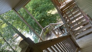 Eine Holzterrasse mit Blick auf einen Fluss und umgebende Grünflächen.