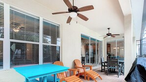 An outdoor patio with a blue table and orange chairs, a ceiling fan, and a barbecue grill. - TOP-RATED WINDSOR HILLS Private Home ♥ Pool/Spa, GAME ROOM ♥ 4 mi to DISNEY (Kissimmee)
