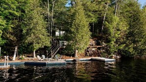 A lakeside cabin with a dock, surrounded by dense forest.