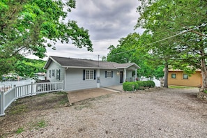 A single-story house with a front porch, a gravel driveway, and a small front yard. - 2 Decks, Dock, Fire Pit! Waterfront Lake Ozark Gem (Lake Ozark)