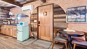 A rustic kitchen with wooden cabinets, a vintage refrigerator, and a wooden door. - Rustic Hobbit Inspired Hocking Hills State Park 3 mi away Hot Tub Pet Friendly  (Creola)