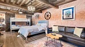 A bedroom with a bunk bed, a sofa, a coffee table, and a rug. - Rustic Hobbit Inspired Hocking Hills State Park 3 mi away Hot Tub Pet Friendly  (Creola)