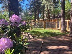 A wooden deck with a fenced area, surrounded by trees and a wooden fence.