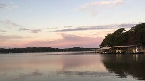 A calm lake with a dock and covered seating area. - Cozy Lake Cabin With Beautiful View! (Gravois Mills)