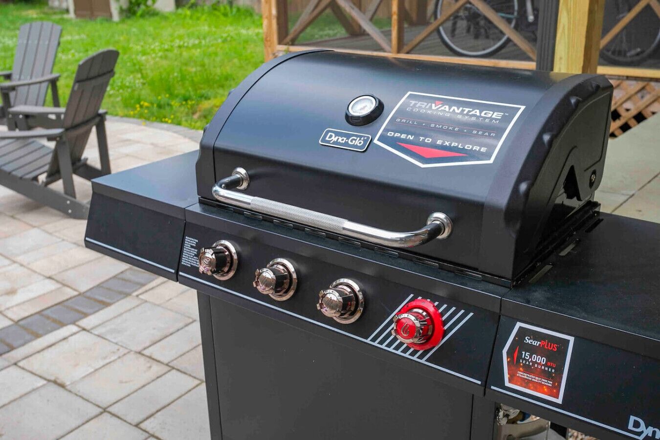 En sort udendørs grill med håndtag, knapper og en mærkat, der angiver at det er et Trivantage kogesystem.