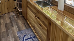 Una cocina moderna con armarios de madera, un lavamanos de acero inoxidable y vistas al exterior.