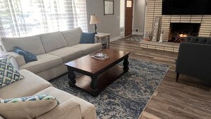 Una sala de estar con sofá, mesa de centro y chimenea.