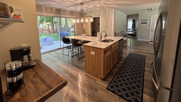 Una cocina moderna con una isla central, encimeras de madera y un refrigerador de acero inoxidable.