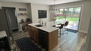 Una cocina moderna con una isla central, un letrero de cafetería y un cartel de bienvenida.